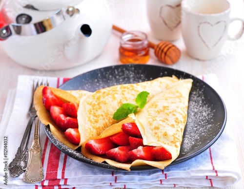 Pancakes with organic strawberries, caramel, cinnamon and mint.
