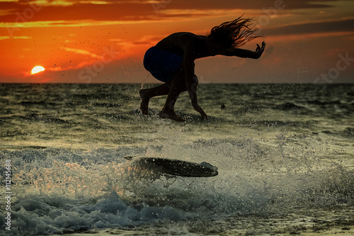 Silhouette of surfer at sunset. Unrecognizable face. 