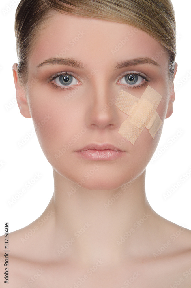 Fototapeta premium Young woman with medical plaster on her face