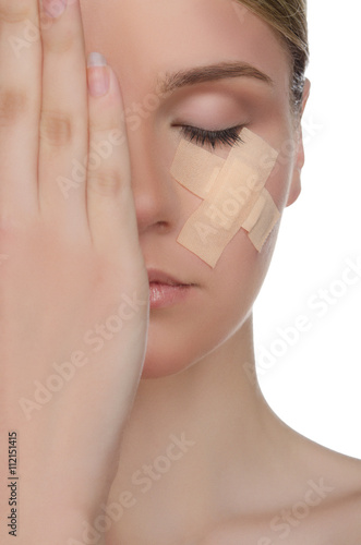 face of young woman with medical patch