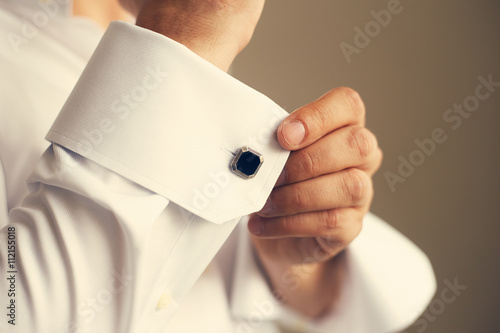 Bild auf Leinwand Man correcting the sleeve of his shirt