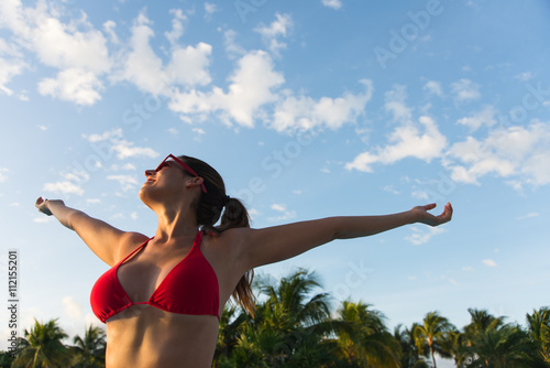 Woman enjoying tropical vacation at caribbean resort swimming pool. Female happy girl having fun at poolside. © Dirima