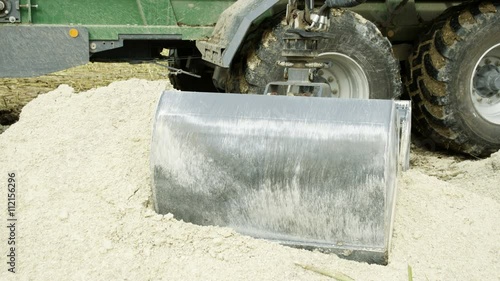 The big clamp of the backhoe getting limestones in powder form from the limestone quarry area