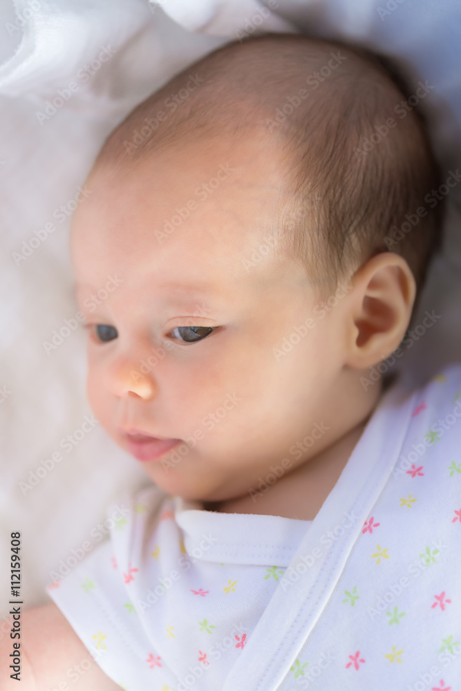 Portrait of a newborn baby looking away from the camera with her Portrait of a newborn baby looking away from the camera with her