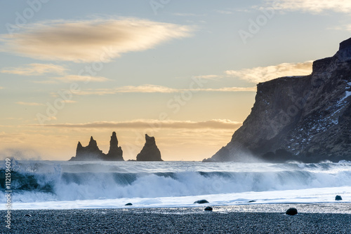 Big waves on the Black sand beach near Reynisdrangar rocks during sunset. Vik, Iceland.