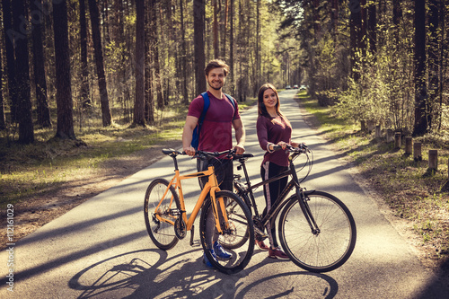 Sporty male and female with bicycles.