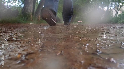 man walking along a road in the rain