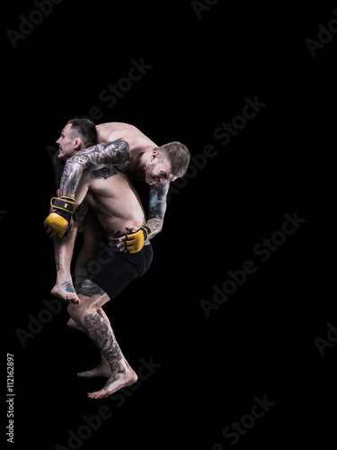 Mixed martial artists fighting on black background © masisyan