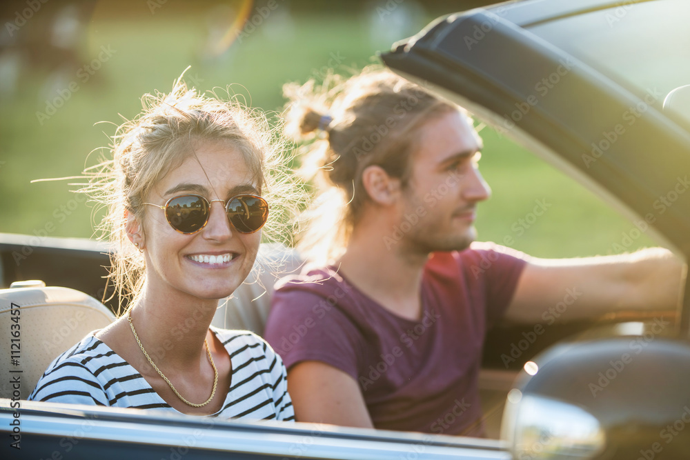 Fototapeta premium Young couple in his convertible car