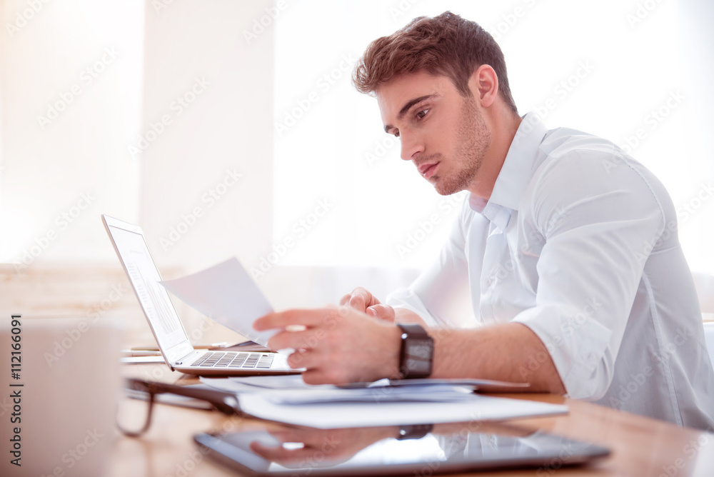 Pleasant busy man sitting at the table Pleasant busy man sitting at the table