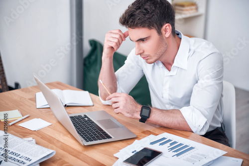 Concentrated man sitting at the table 