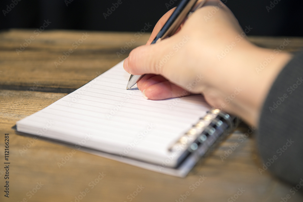 Writing in a book. Low light for ambience. Writing in a book. Low light for ambience.