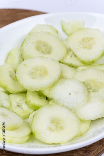 Sliced cucumbers on the plate, macro close up flat lay.