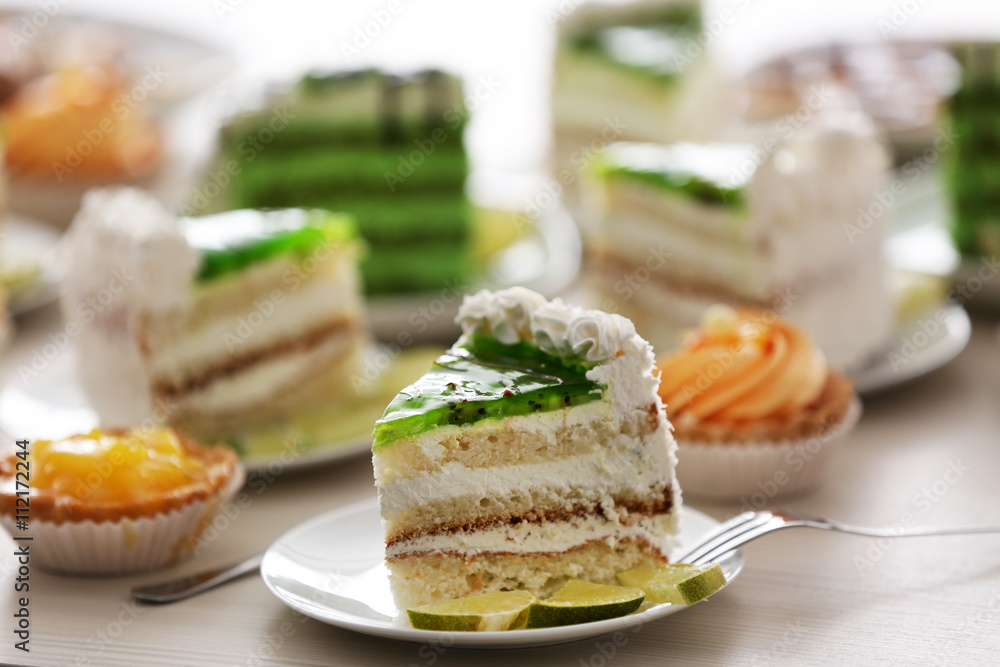 Pieces of lime cake and fruit tarts on table Pieces of lime cake and fruit tarts on table