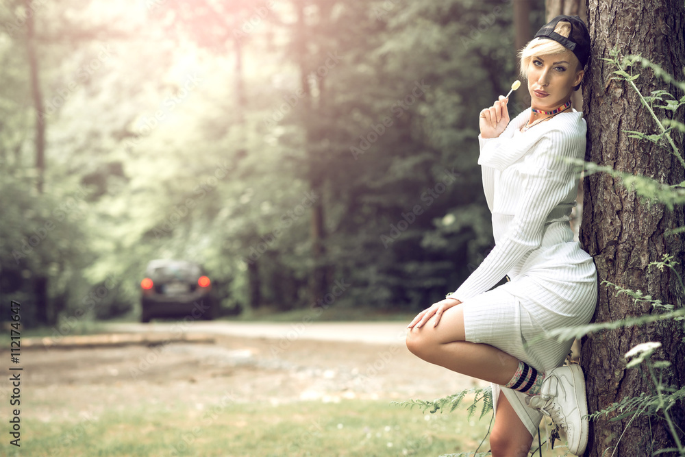 Swag attractive female girl posing with lollipop in nature.