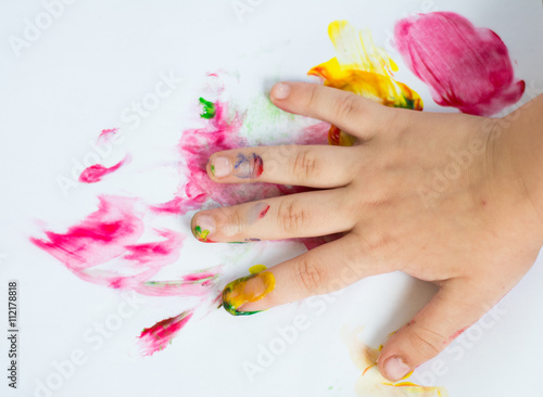 Hand of child while doing finger paint photo