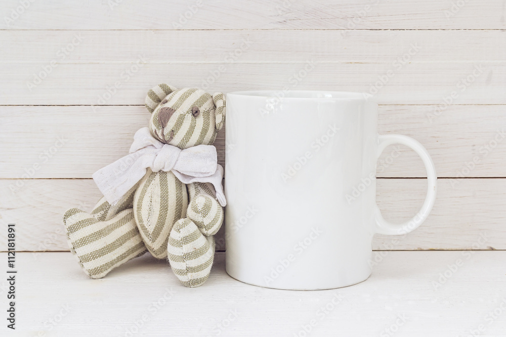 Fotografie White coffee mug with Teddy bear. Space for design.