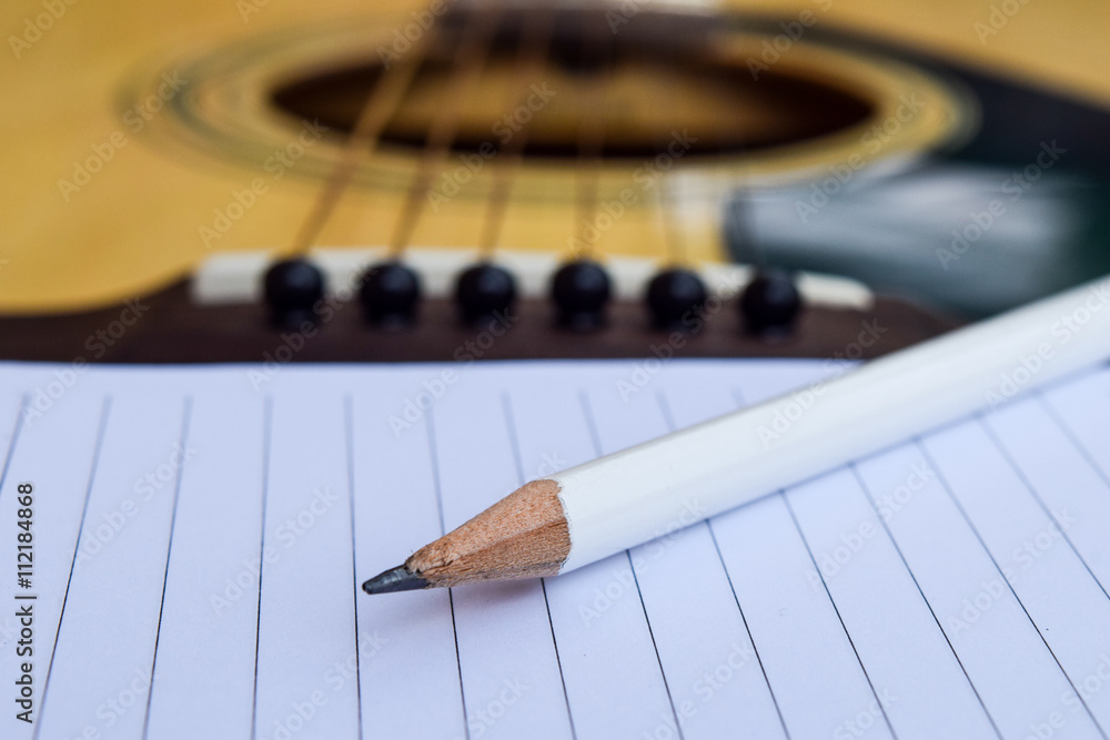 Fototapeta premium Guitar and Blank notepad with pencil