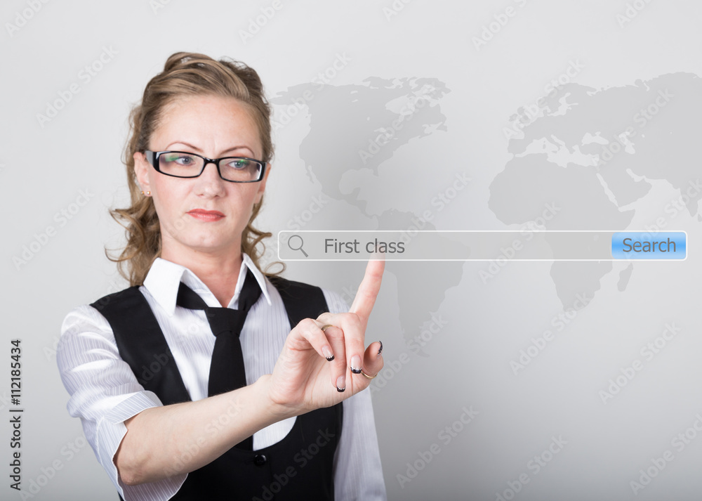 first class written in search bar on virtual screen. Internet technologies in business and home. woman in business suit and tie, presses a finger on a virtual screen first class written in search bar on virtual screen. Internet technologies in business and home. woman in business suit and tie, presses a finger on a virtual screen
