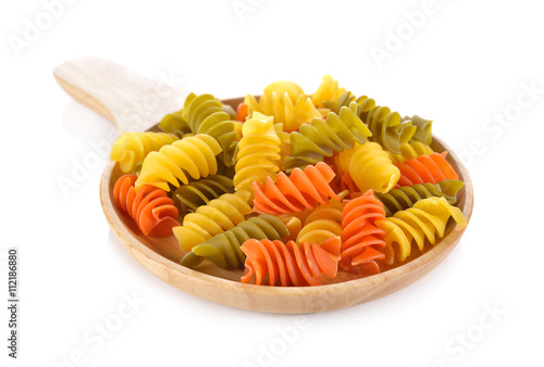 Large vegeroni Rotini spirals pasta in wooden plate on white bac photo