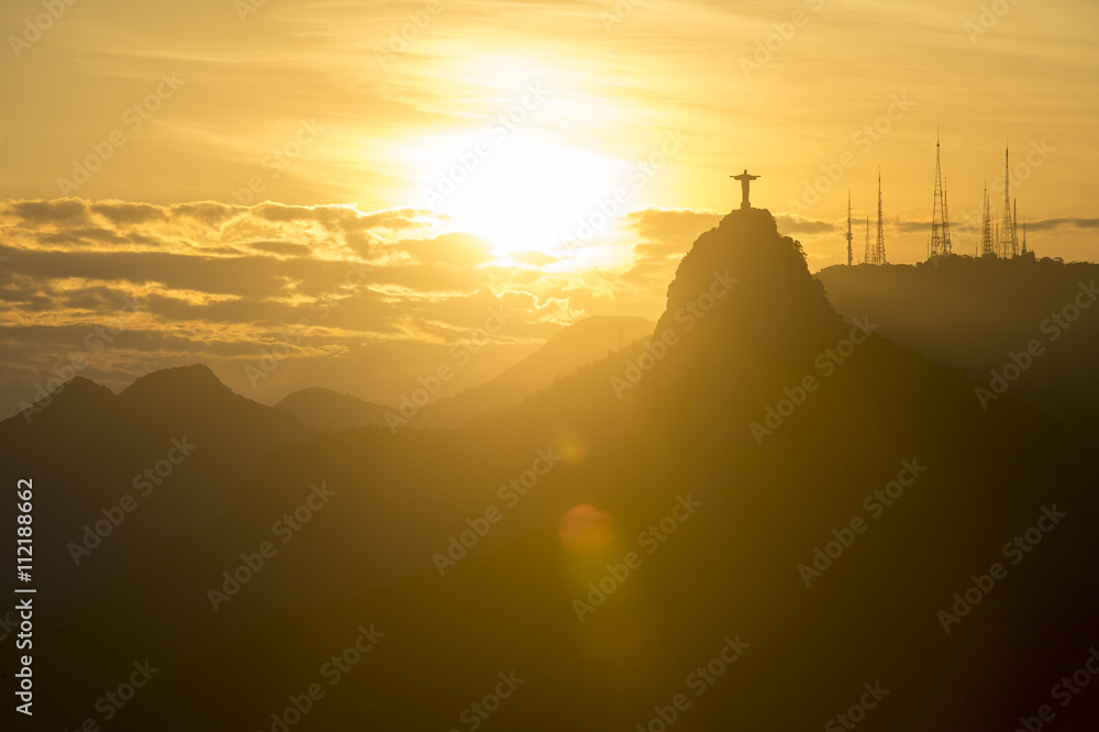 Corcovado Mountain Christ the Redeemer standing in golden sunset clouds Rio de Janeiro Brazil