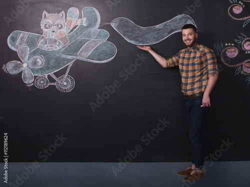 Portrait of freelance man posing near black wall in full length. Happy man in jeans and thirt making business over black background.  photo