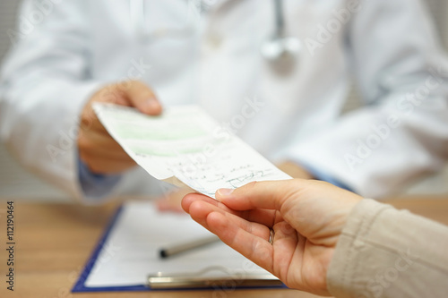 doctor is giving a prescription to a female patient photo
