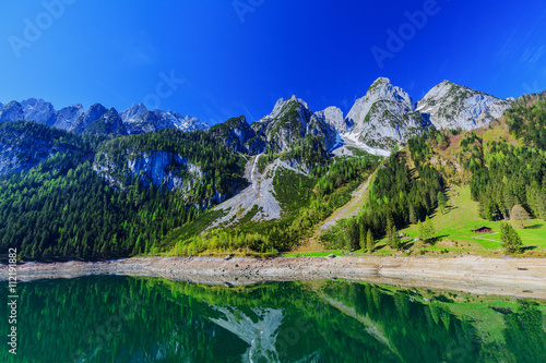 The snow-covered peaks in the Alps with a beautiful green mounta