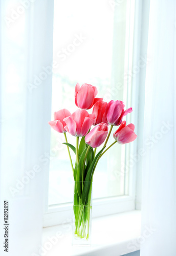 Pink tulips in vase on the windowsill © 5second