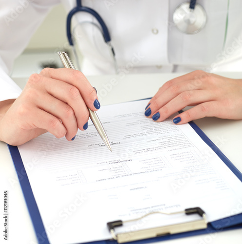 Female medicine doctor hand holding silver pen writing something