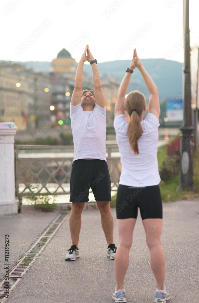 couple warming up before jogging
