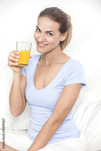 Young beautiful smiling woman with glass of orange juice