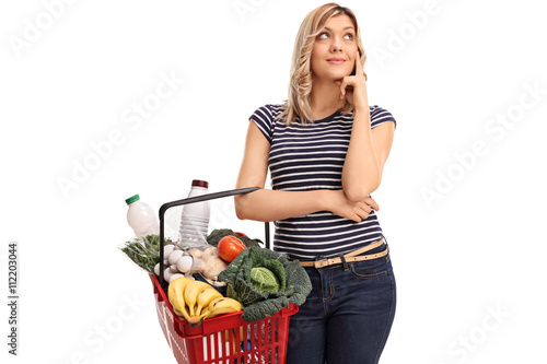 Quadro em tela Pensive woman holding a shopping basket