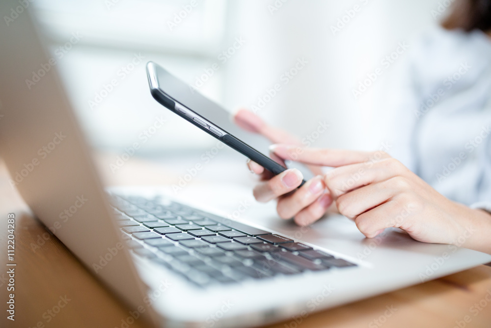 Female hands using smart phone and working with computer Female hands using smart phone and working with computer