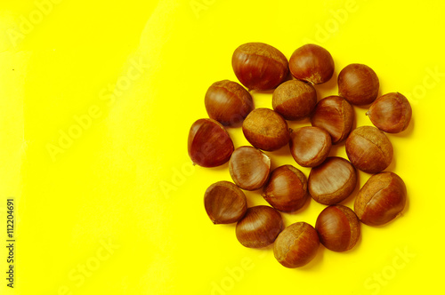 Chestnuts pattern on yellow background top view chestnut