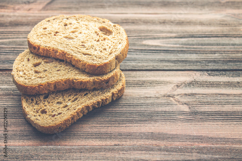 Slices of rye bread on a wooden background