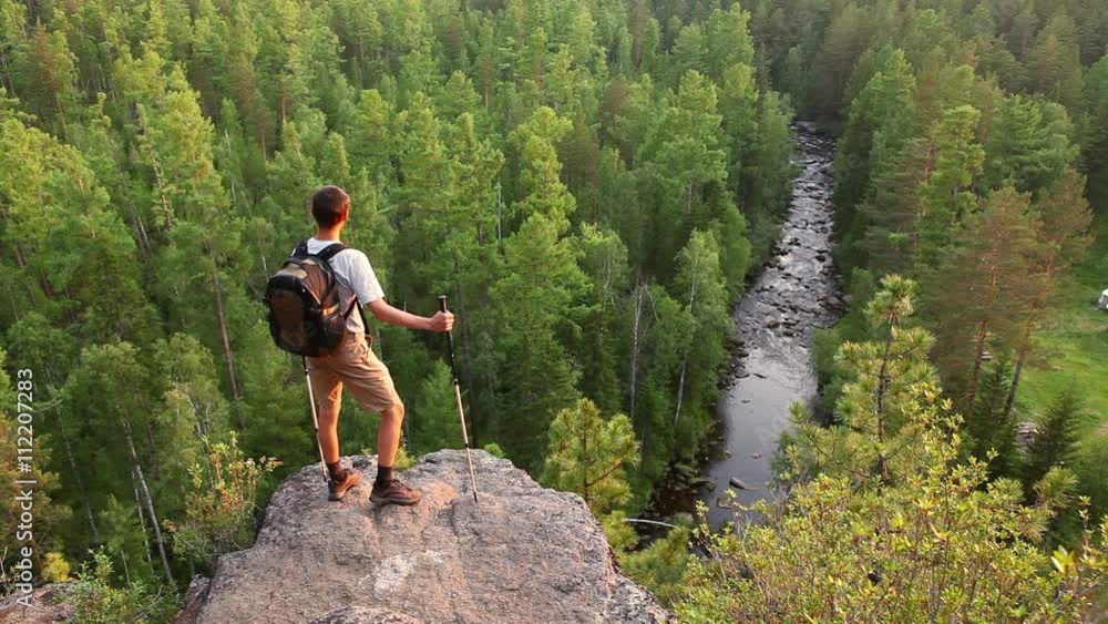 Hiker with backpack standing on a mountain Hiker with backpack standing on a mountain