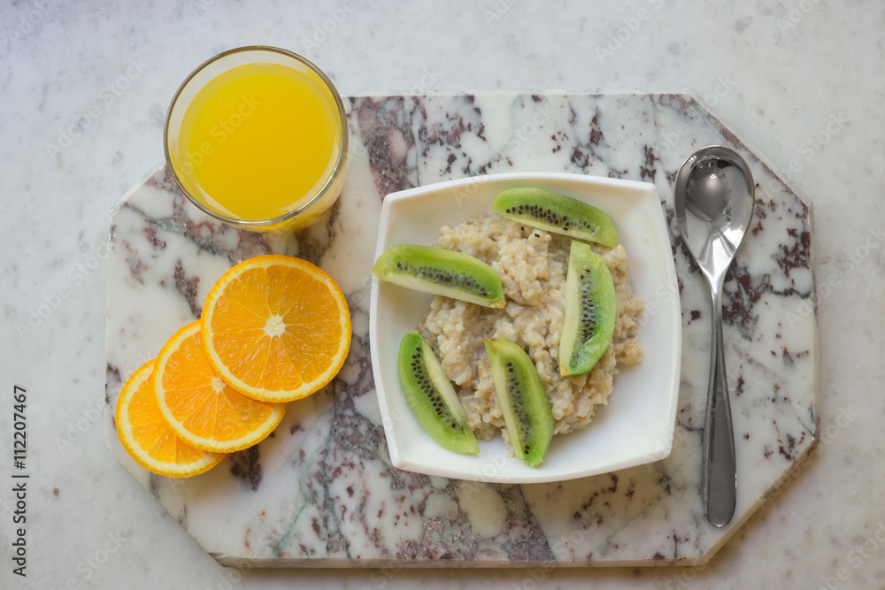 Bowl of oatmeal porridge with kiwi on marble table Bowl of oatmeal porridge with kiwi on marble table