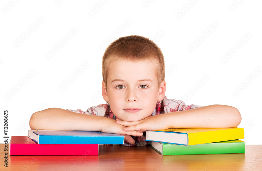 Cute little boy sitting at table with books on white. Cute little boy sitting at table with books on white.