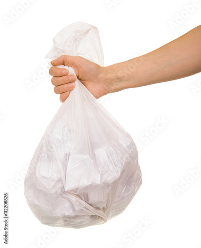 Transparent plastic bag with paper waste in  female hand isolated.