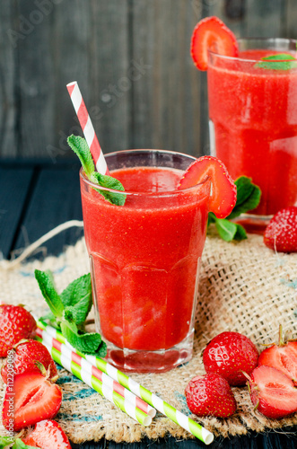  Summer refreshing healthy drink , strawberry smoothie or fresh with mint on a wooden background