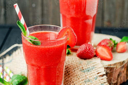  Summer refreshing healthy drink , strawberry smoothie or fresh with mint on a wooden background
