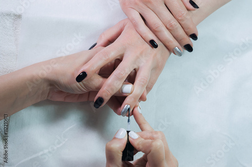 Nails transparent coating is a close-up in beauty salon. Manicure process.