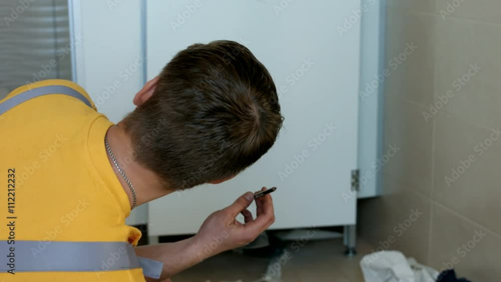 Two Workers Install a New Door in the Toilet Cubicle Two Workers Install a New Door in the Toilet Cubicle