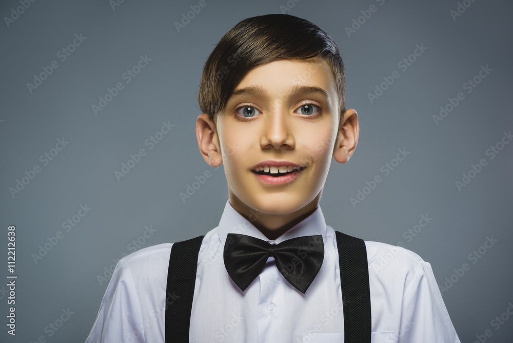 Closeup Portrait of happy boy going surprise isolated on gray background Closeup Portrait of happy boy going surprise isolated on gray background
