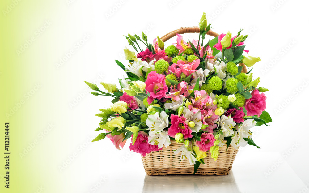Beautiful bouquet of bright flowers in basket . Isolated on whit