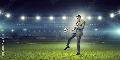 Businessman kicking ball © Sergey Nivens