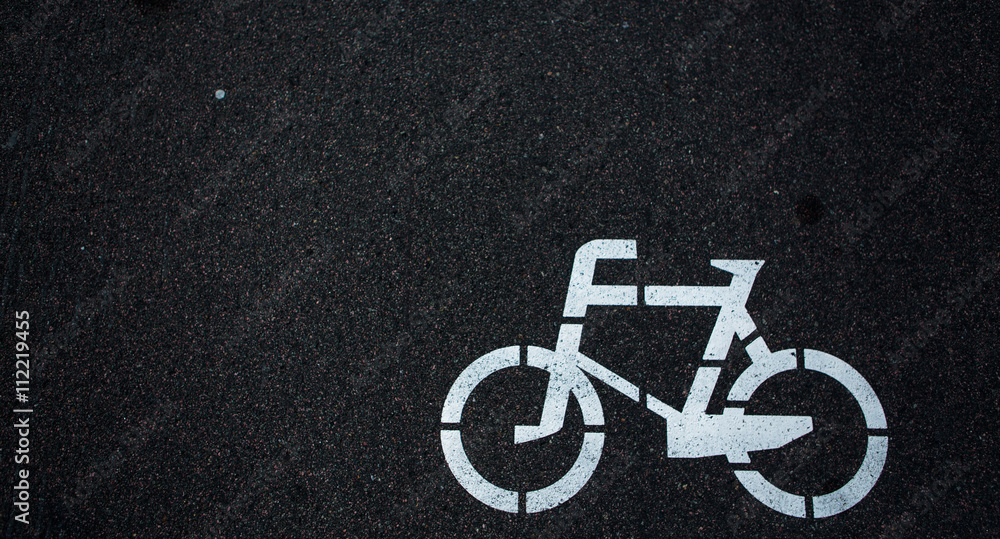 Bicycle road sign of white colour on road. Bicycle sign path on road, bikes' lane on outskirts or urban area. Bicycle road sign of white colour on road. Bicycle sign path on road, bikes' lane on outskirts or urban area.