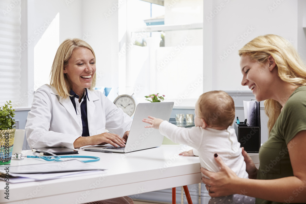 Mother And Baby Meeting With Female Doctor In Office