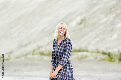 The happy girl in a checkered dress outdoors.